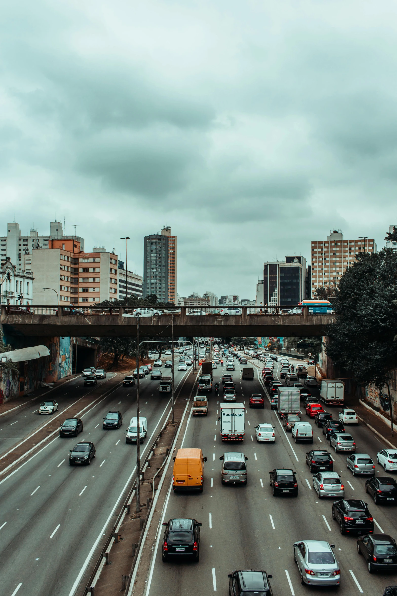 a highway filled with lots of traffic next to tall buildings, by Alejandro Obregón, brazil, 🚿🗝📝