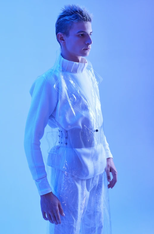 a man in a white suit standing in front of a blue background, inspired by Gao Cen, unsplash, neo-dada, model is wearing techtical vest, transparent carapace, plastic and fabric, translucent dress