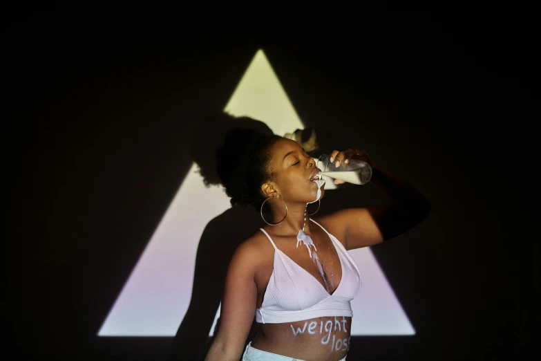a woman in a white top drinking from a bottle, a hologram, triangle, wearing a crop top, performance art, ( ( dark skin ) )