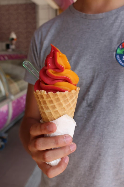 a close up of a person holding an ice cream cone, vivid ember colors, colored fruit stand, patagonian, swirles