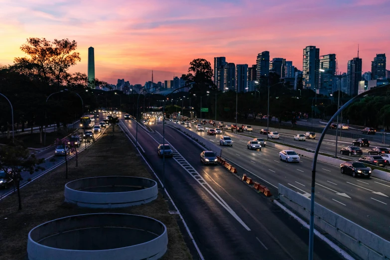 a highway filled with lots of traffic next to tall buildings, by Felipe Seade, pexels contest winner, sunset panorama, oscar niemeyer, australia, thumbnail