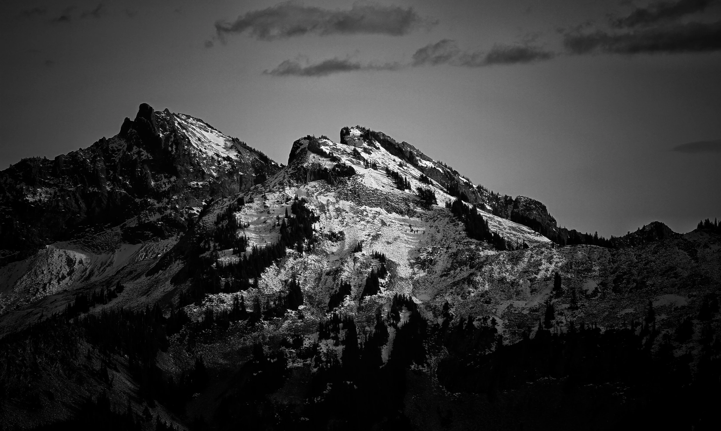 a black and white photo of a mountain, figuration libre, high contrast dappled lighting, at the top of a mountain, cascadia, evening lighting