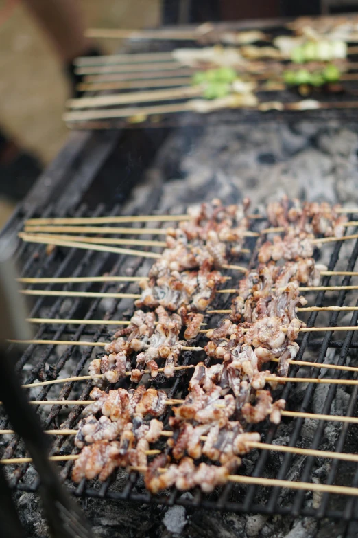a close up of skewered meat on a grill, by Lee Loughridge, hurufiyya, multiple stories, larapi, a high angle shot, low quality photo
