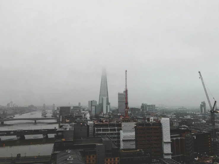 a view of a city from the top of a building, inspired by Thomas Struth, pexels contest winner, modernism, under a gray foggy sky, the shard, background image, rainy