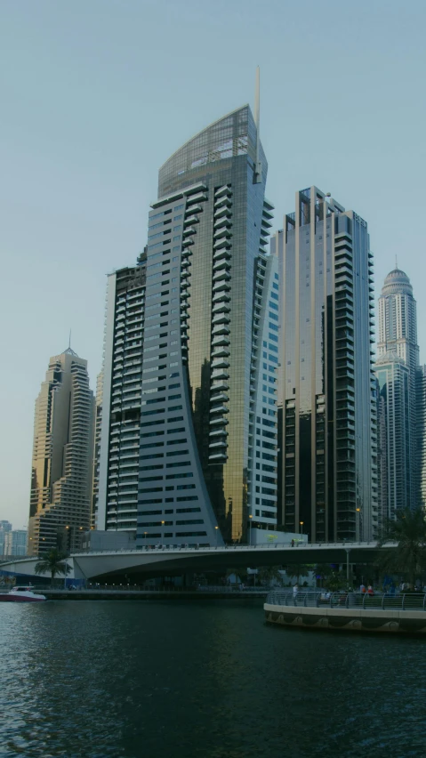 a large body of water surrounded by tall buildings, inspired by Zaha Hadid, hurufiyya, exterior, thumbnail, dubai, buildings covered in black tar