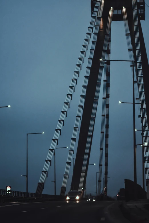 a black and white photo of a bridge at night, poster art, by Jacob Toorenvliet, pexels contest winner, postminimalism, three masts, industrial colours, desaturated blue, zoomed in