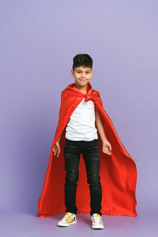 a young boy wearing a red cape and black pants, non-binary, hero prop, red and purple, vivid)