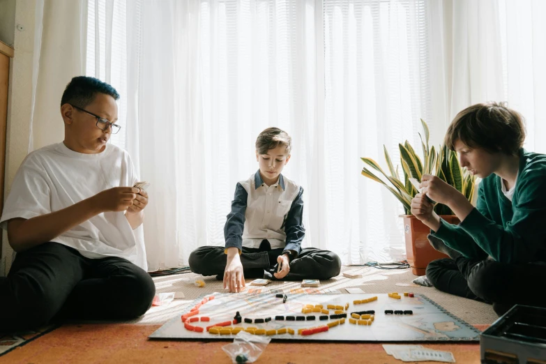 a family sitting on the floor playing a board game, pexels contest winner, avatar image, engineer, boys, ad image