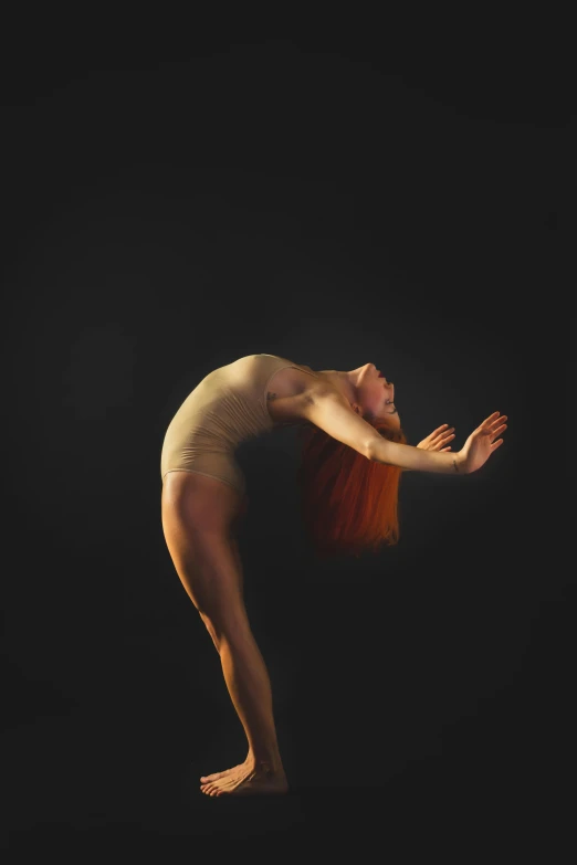 a woman that is standing in the dark, an album cover, inspired by Elizabeth Polunin, unsplash, arabesque, long orange hair floating on air, bend over posture, studio medium format photograph, wearing leotard