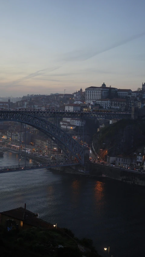 a bridge over a large body of water, inspired by Oswaldo Viteri, pexels contest winner, art nouveau, cliffside town, dusk, square, aerial footage