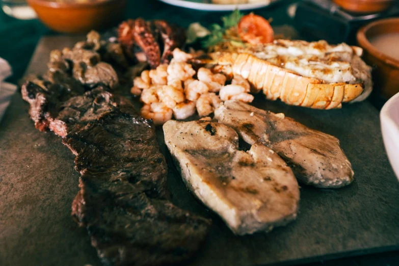 a close up of a plate of food on a table, meats on the ground, oceanside, cooked to perfection, thumbnail