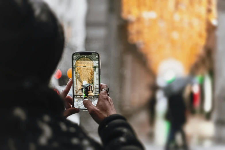 a person holding up a cell phone to take a picture, a picture, by Joe Bowler, pexels contest winner, street perspective, pixelated, 🦩🪐🐞👩🏻🦳, 🤠 using a 🖥