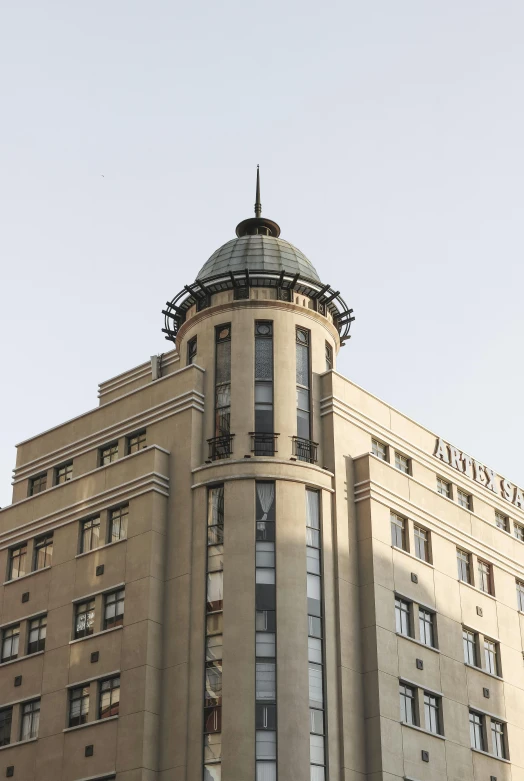 a tall building with a clock on top of it, akitipe studios, art deco era), seen from afar, front lit