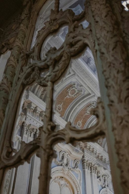 a view of the inside of a building through a window, by Cagnaccio di San Pietro, unsplash contest winner, rococo, detailed filigree, archways between stalagtites, 8k detail, classicism