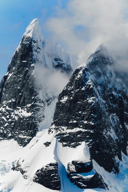 a group of people standing on top of a snow covered mountain, devils horns, seen from a distance, monoliths, ice seracs