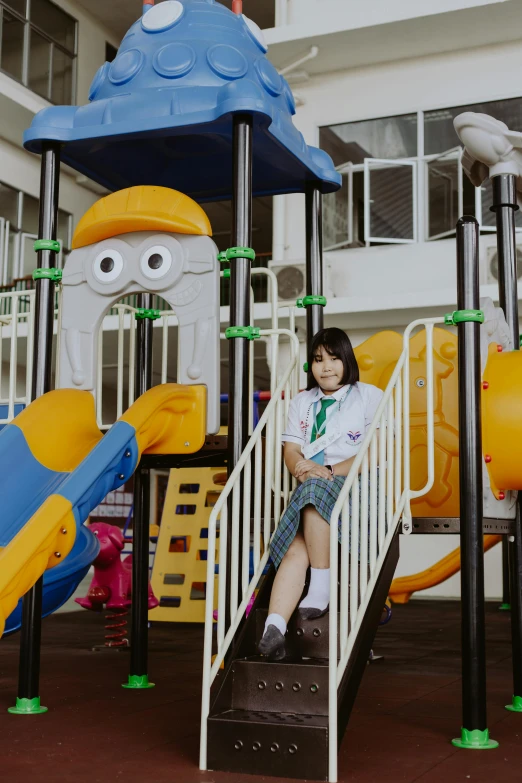 a little girl that is sitting on a slide, a cartoon, inspired by Ke Jiusi, pexels contest winner, wearing school uniform, inside a science facility, square, low quality photo