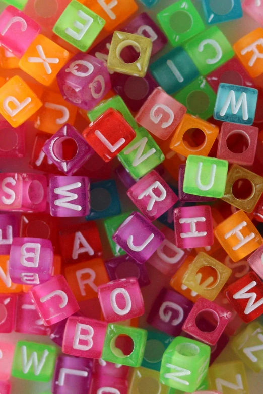 a pile of plastic letters sitting on top of a table, beads, thumbnail, licking, square