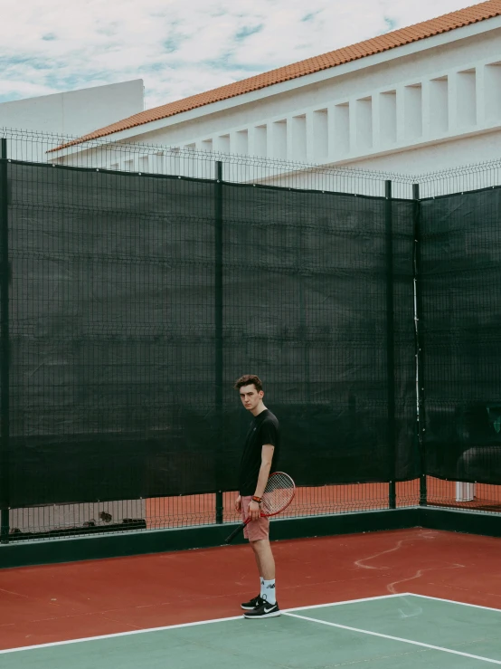 a man standing on a tennis court holding a racquet, an album cover, inspired by Ion Andreescu, pexels contest winner, trending on vsco, full body photo, in barcelona, freddy mamani silvestre facade