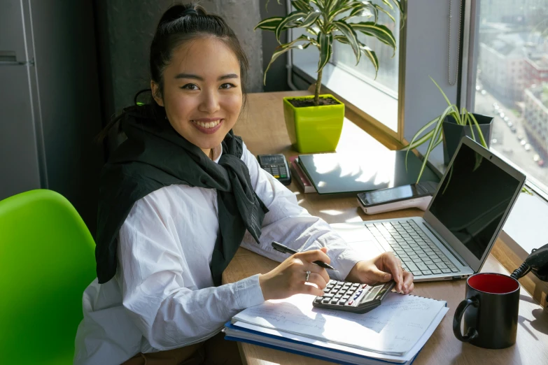 a woman sitting at a desk with a calculator, pexels contest winner, bao pham, subtle confident smile, avatar image, student