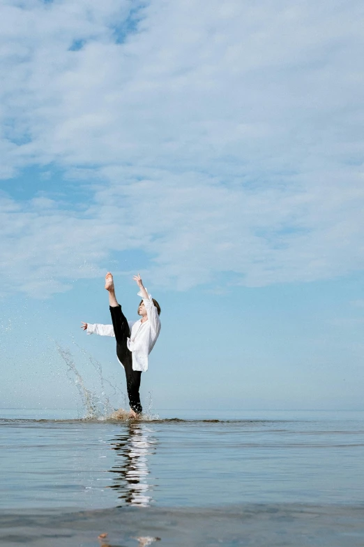 a man standing in the middle of a body of water, arabesque, dabbing, blue sky, heath clifford, seaside