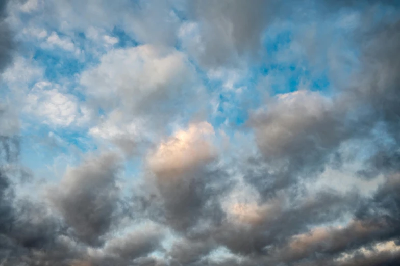 a group of people standing on top of a beach under a cloudy sky, an album cover, by Daniel Seghers, unsplash, romanticism, layered stratocumulus clouds, close - up photograph, looking up onto the sky, soft light - n 9