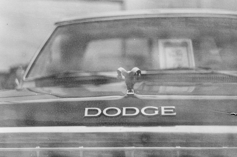 a black and white photo of a dodge hood ornament, an album cover, by Roy DeCarava, 1977, ffffound, woodstock, grainy film photograph