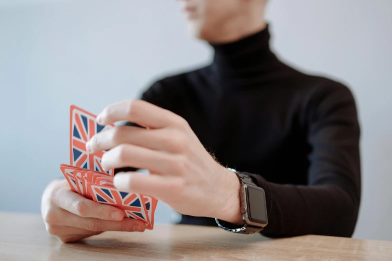 a man sitting at a table playing a card game, an album cover, unsplash, union jack, avatar image, no - text no - logo, holding controller