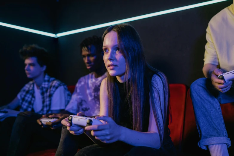 a group of people sitting on a couch playing a video game, pexels, realism, photo of young woman, in dark room, serious expression, high school