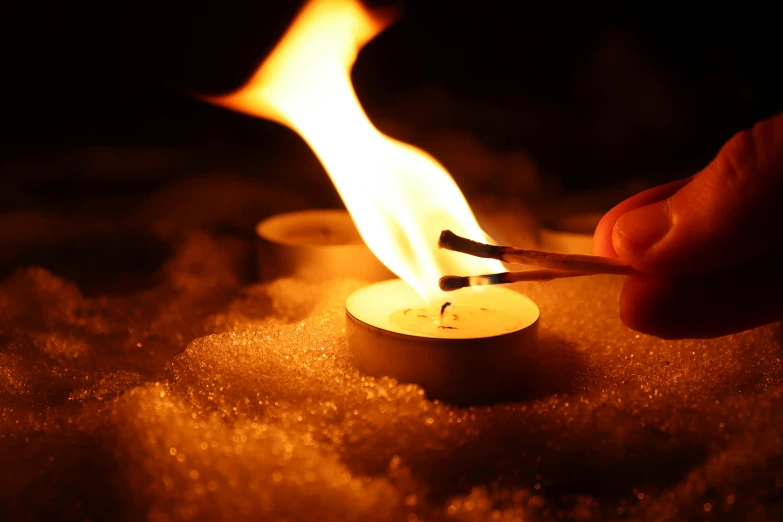 a person lighting a candle in the snow, trending on pexels, avatar image, arson, tiny firespitter, candle volumetric