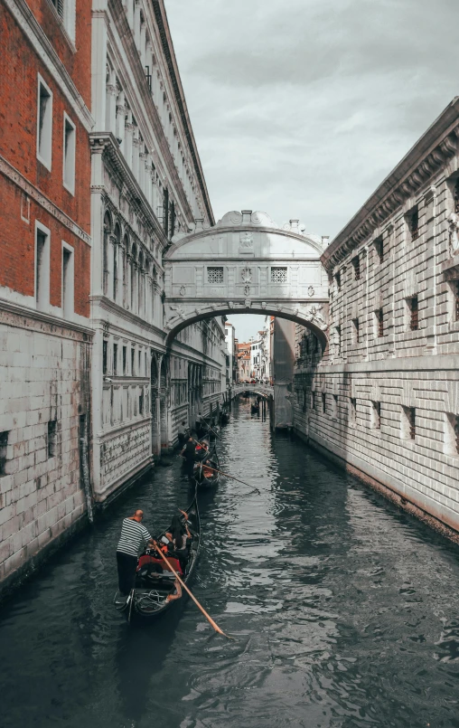 a couple of boats that are in the water, a photo, by Robbie Trevino, pexels contest winner, renaissance, all buildings on bridge, water running down the walls, panoramic shot, gondola