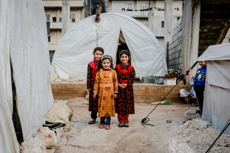 a group of children standing in front of a tent, pexels contest winner, dau-al-set, buildings carved out of stone, arper's bazaar, sisters, demna gvasalia