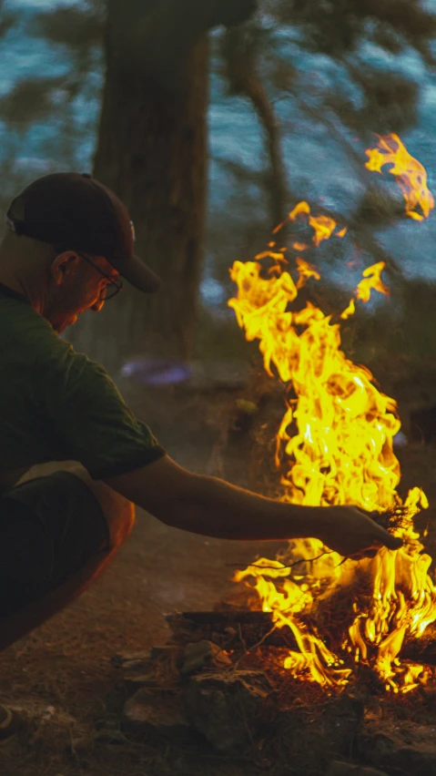 a man kneeling over a fire in the woods, profile image, low quality photo, instagram photo, digitally enhanced