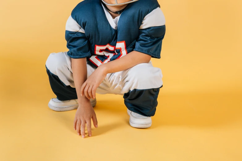 a young boy in a football uniform crouching down, a cartoon, trending on pexels, lycra costume, navy, kid named finger, 40 years old women