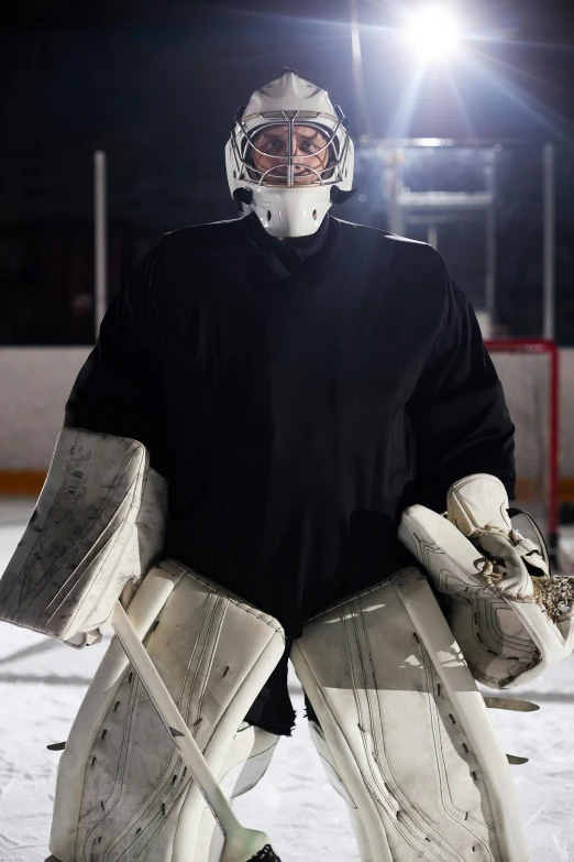 an image of a hockey goalie on the ice, a portrait, promo image, no - text no - logo, holding helmet, off camera flash