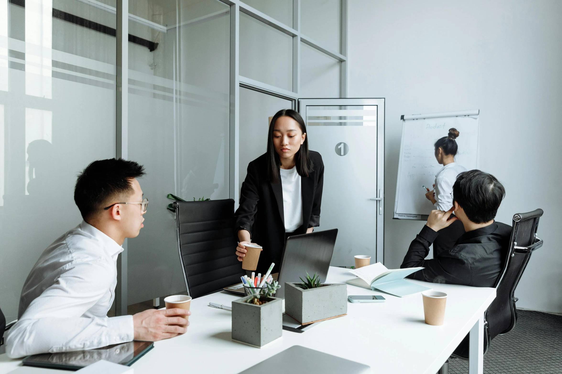 a group of people sitting around a table with laptops, by Jang Seung-eop, pexels contest winner, cubical meeting room office, standing up, minimalistic design, asian female