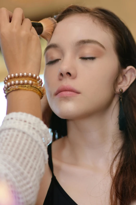 a woman is getting her make up done, by Gavin Hamilton, trending on pexels, renaissance, bracelets, portrait sophie mudd, pale-skinned, gold and pearls