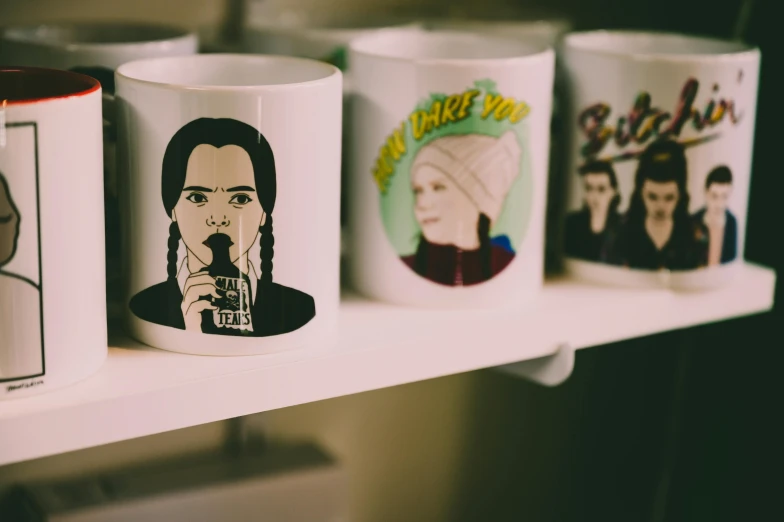 a row of coffee mugs sitting on a shelf, a cartoon, by Julia Pishtar, trending on pexels, pop art, billie eilish as a nun, riverdale, gilmore girls aesthetic, gal gadot china plate