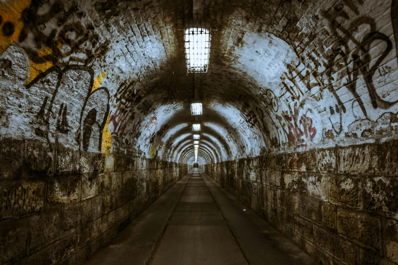 a long tunnel with graffiti on the walls, inspired by Elsa Bleda, pexels contest winner, graffiti, military buildings, historical photo, getty images, photo of scp-173