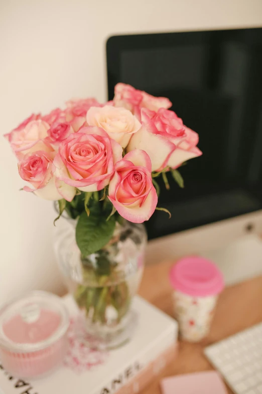 a vase filled with pink roses sitting on top of a desk, pexels, fully decorated, cosy, close together, hazy