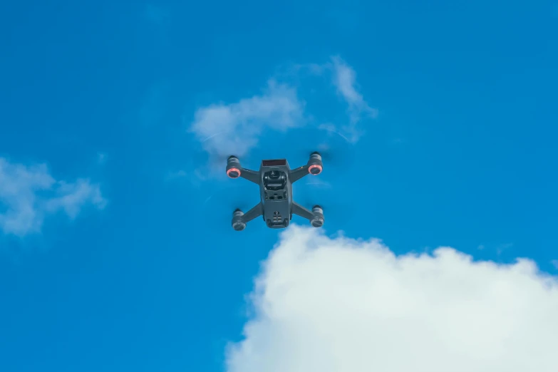 a black drone flying through a blue sky, unsplash, figuration libre, square, low quality photo, high - resolution scan, farsight xr-20