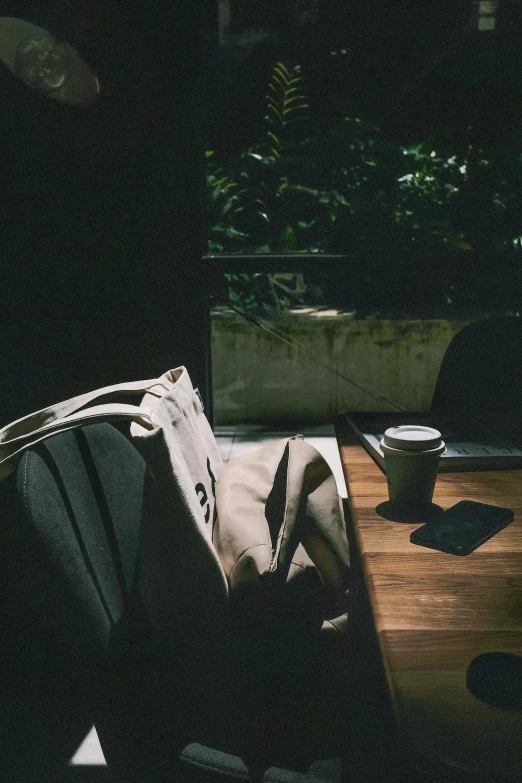 a laptop computer sitting on top of a wooden table, unsplash contest winner, australian tonalism, comfy chairs, bags on ground, dark university aesthetic, looking out