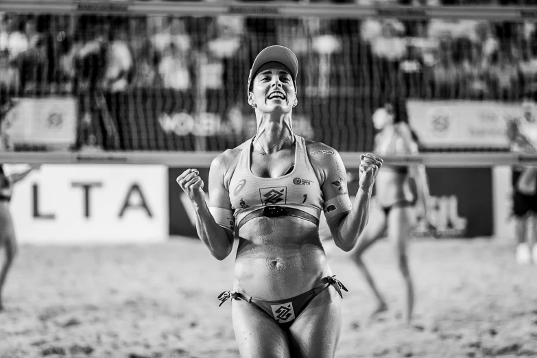 a woman standing on top of a sandy beach, a black and white photo, figuration libre, tournament, she is smiling and excited, caio santos, oliver vernon