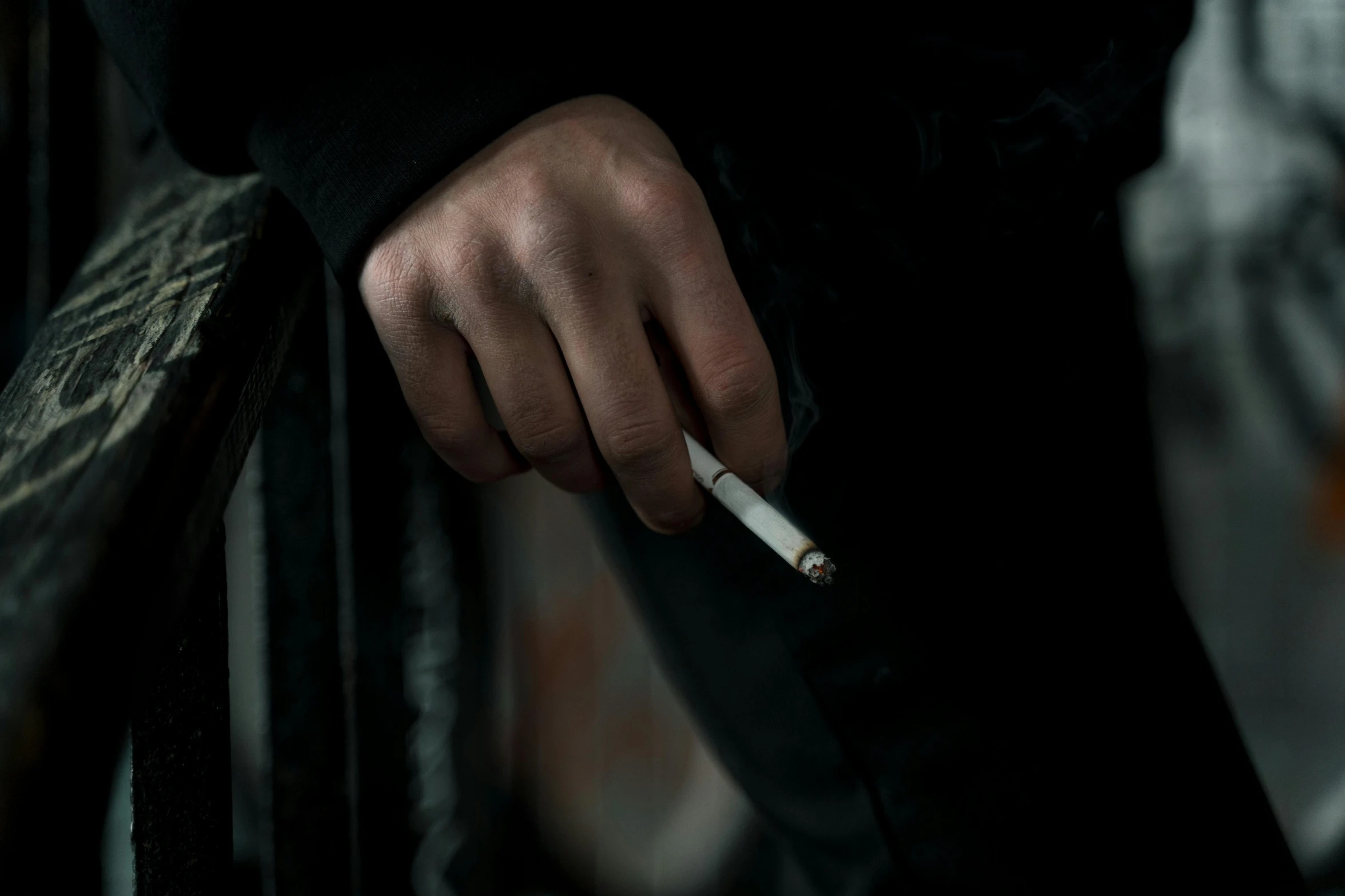 a person holding a cigarette in their hand, by Elsa Bleda, pexels contest winner, hyperrealism, background ( dark _ smokiness ), white male, pathetic, [ cinematic