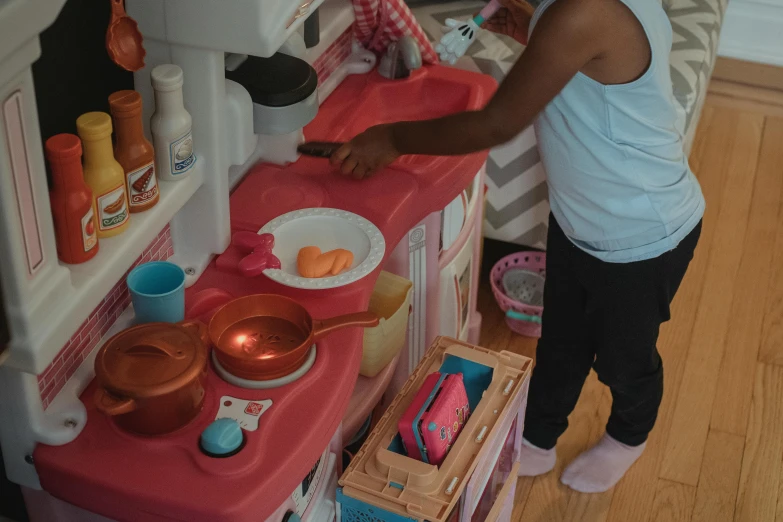 a little girl standing in front of a toy kitchen, pexels contest winner, ( ( dark skin ) ), taking from above, paw pov, gameplay