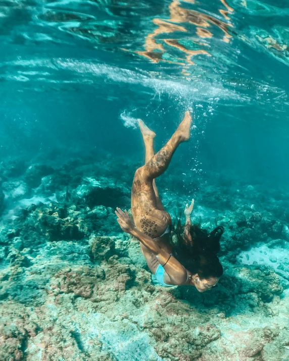 a person swimming in a body of water, at the bottom of the ocean