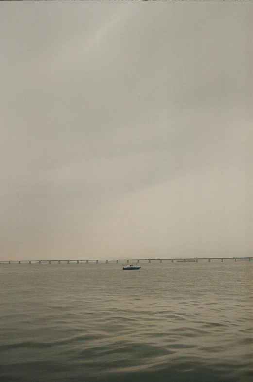 a boat in the middle of a large body of water, a picture, by Zhang Kechun, city bay bridge aqueduct, grainy low quality photograph, photograph ”