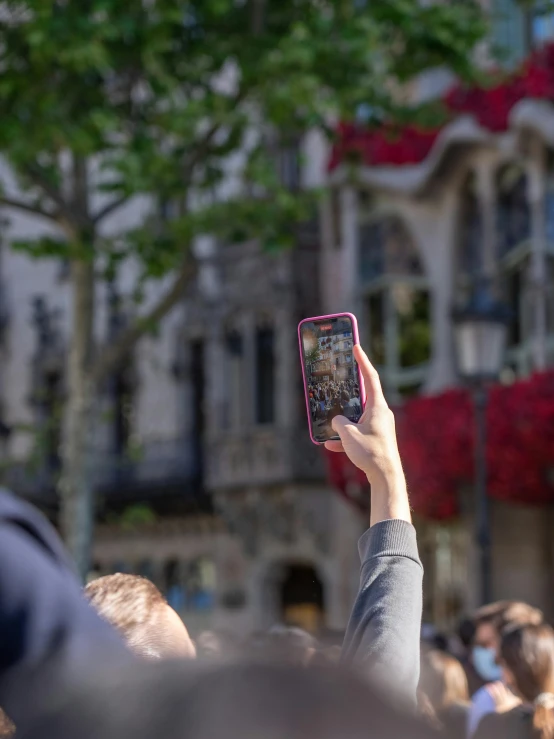 a person taking a picture with a cell phone, by Niko Henrichon, pexels contest winner, happening, antoni gaudi, giving a speech, lgbtq, college