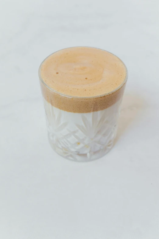 a close up of a cup of coffee on a table, vanilla smoothie explosion, 3/4 front view, thumbnail, with clear glass