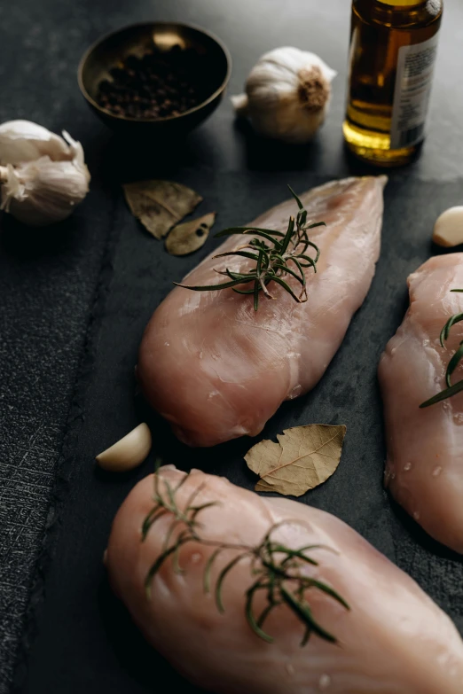 a couple of raw chicken sitting on top of a table, a picture, trending on pexels, renaissance, on a dark background, 6 pack, herbs, including a long tail