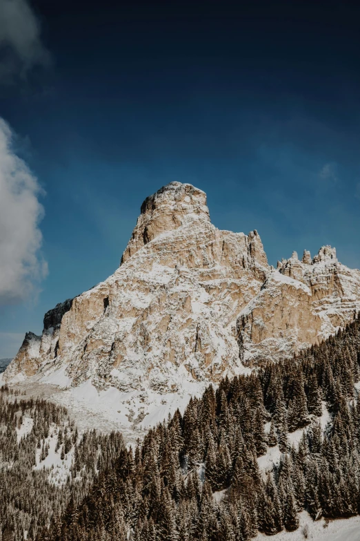 a man riding skis down a snow covered slope, an album cover, by Carlo Martini, pexels contest winner, renaissance, chiseled formations, panorama view, dolomites, brown